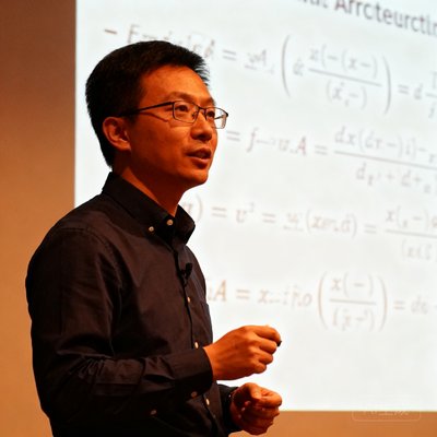 张明远博士，美狮贵宾会创始人兼CEO，四十岁出头，戴着眼镜，穿着深色衬衫，在技术会议上讲解架构设计，背景是白板上的复杂算法公式。